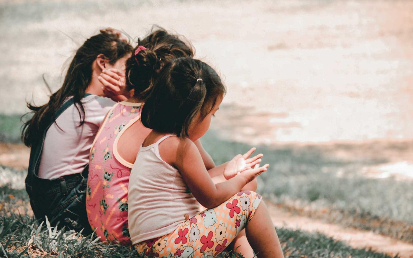 Kids sitting on a bench.